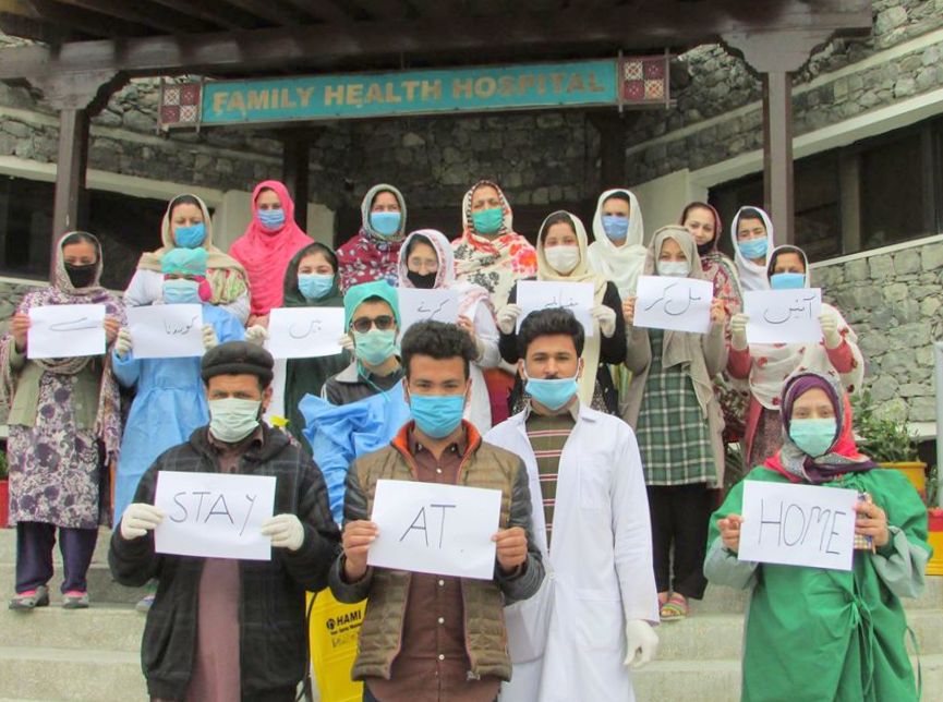 Staff from one of Rahnuma's clinics in Pakistan ask people to stay at home