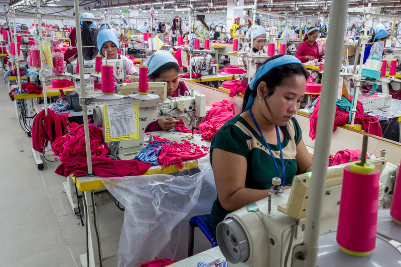 A group of garment workers work on the production line inside the Propitious garment factory in Krong Ta Khmau city. The factory employs more than 3,500 workers and specializes in children's clothes, but also produces a variety of men and women's clothes. The factory has seen a rise in productivity and a reduction in staff taking sick days since RHACs' health outreach programme has been introduced.  