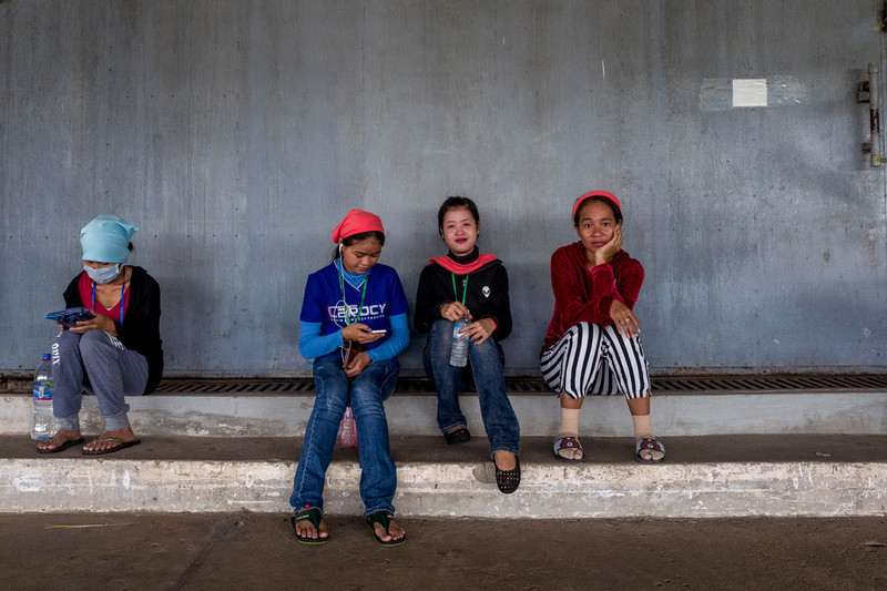 Garment workers sit inside the Propitious Cambodia garment factory during their lunch break in Krong Ta Khmau city.