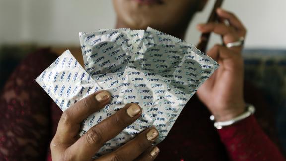 Leilani from Tonga holds up a pile of condoms